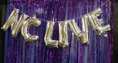 Silver balloon letters that spell "NC LIVE."